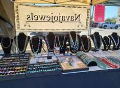 Jewelry display on a table with Navajojewels banner above